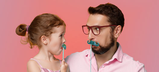 padre e hija con un bigote de papel poniendo cara divertida