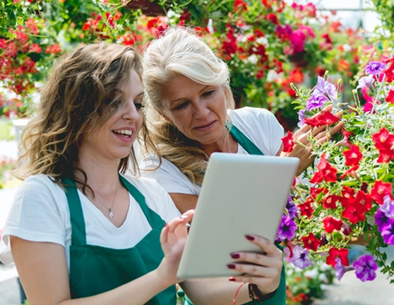 Dos mujeres floristas consultando desde la tablet algunos detalles